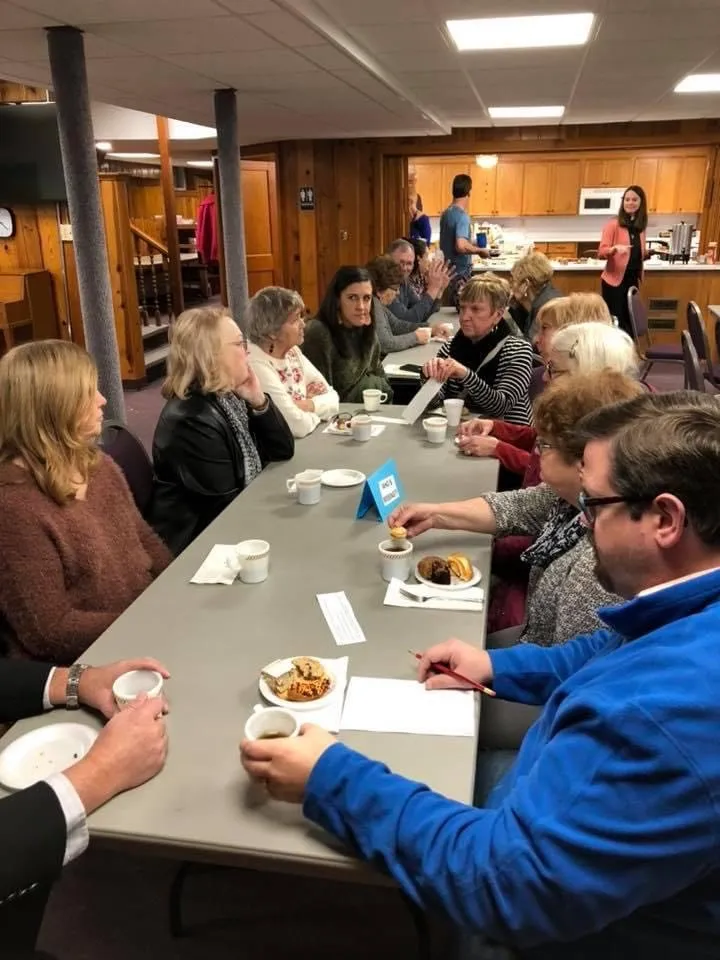 Members of the congregation enjoying conversation around the table